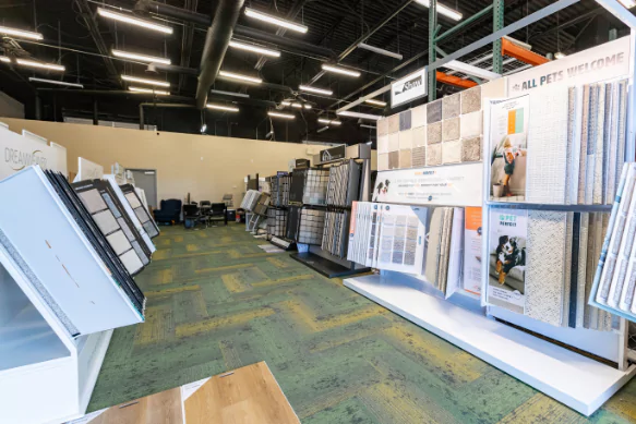 Interior view of a flooring showroom displaying various carpet and hard surface samples by EZ Flooring.